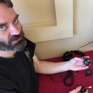 A photo of Drew holding a R0DE Wireless Go II unit in one hand while talking about it