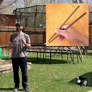 Smiling man with a beard speaking in his back yard with an imposed image of someone using chopsticks in the upper right-hand corner of the frame.